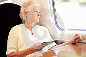 Senior Woman Reading E Book On Train Journey