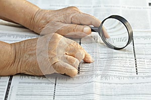 Senior woman reading stock listings