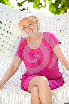 Senior Woman Relaxing In Beach Hammock