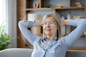 Senior woman relaxing with eyes closed in her living room