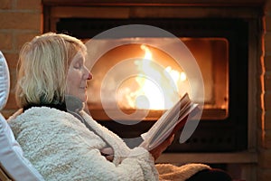 Senior woman relaxing by fireplace