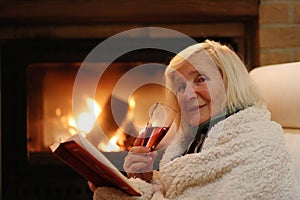 Senior woman relaxing by fireplace