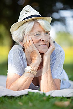 senior woman relaxing in garden by tree