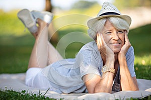 senior woman relaxing on grass in park