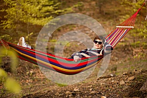 Senior woman relaxing in hammock in forest