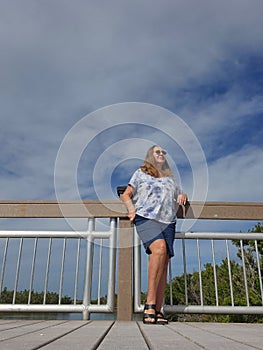 Senior woman relaxing on river bridge