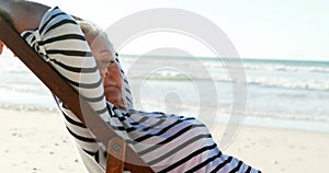 Senior woman relaxing on sunlounger at beach