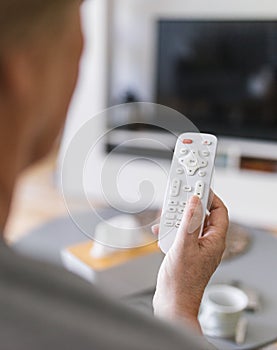 Senior woman with remote control watching tv