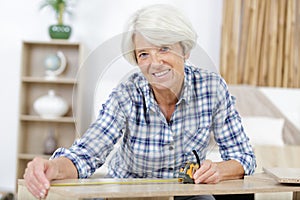senior woman repairing furniture at home