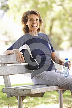 Senior Woman Resting After Exercise In Park