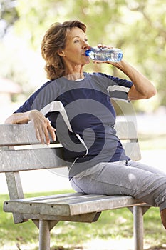 Senior Woman Resting After Exercise In Park