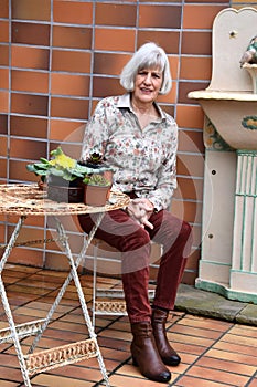 Senior woman resting in her garden on her terrace