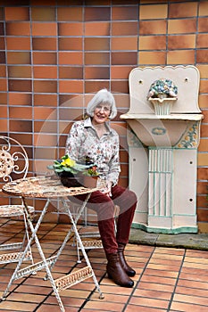 Senior woman resting in her garden on her terrace