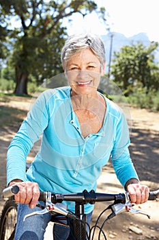 Senior woman riding through countryside