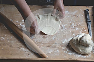 Senior woman roll fresh made pastry, preparing ingrediets for ho