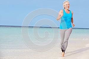 Senior Woman Running On Beautiful Beach