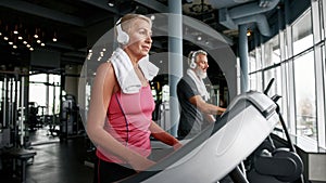 Senior woman running on treadmill to stay fit