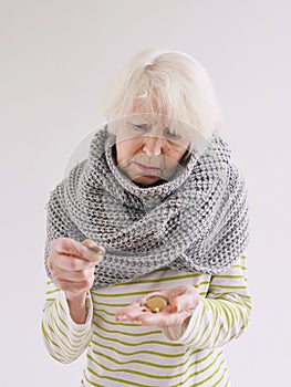 Senior woman in scarf counting coins.