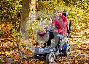 Senior woman with scooter in the park photo