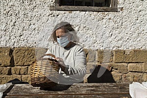 A senior woman, searches for something in a basket, Spain
