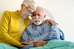 Senior woman with seriously ill husband in hospital. Healthcare support anxiety love concept