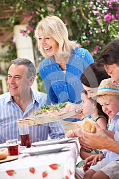 Senior Woman Serving A Family Meal