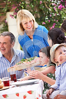 Senior Woman Serving A Family Meal