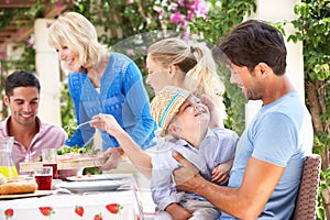 Senior Woman Serving A Family Meal