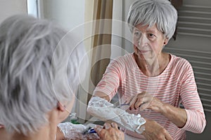 Senior woman shaving her hairy forearms