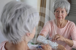 Senior woman shaving her hairy forearms