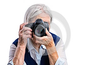 Senior woman shooting with a digital camera.