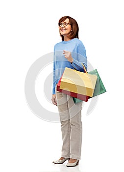 Senior woman with shopping bags isolated on white