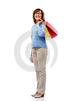 Senior woman with shopping bags isolated on white