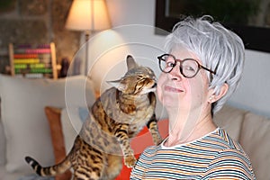 Senior woman showing complicity with her pet photo