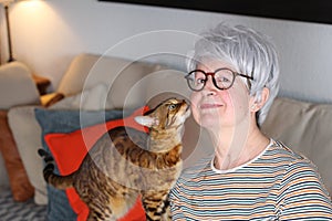 Senior woman showing complicity with her pet photo