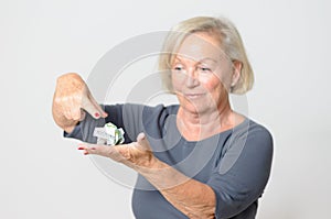 Senior Woman Showing Crumpled Money on Hand