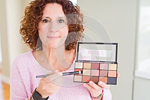 Senior woman showing nudes eyeshadows colors with a confident expression on smart face thinking serious