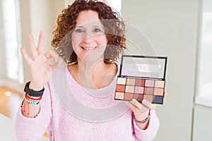 Senior woman showing nudes eyeshadows colors doing ok sign with fingers, excellent symbol