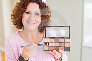 Senior woman showing nudes eyeshadows colors with a happy face standing and smiling with a confident smile showing teeth