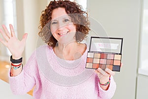 Senior woman showing nudes eyeshadows colors very happy and excited, winner expression celebrating victory screaming with big