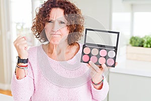 Senior woman showing palette of pink blush annoyed and frustrated shouting with anger, crazy and yelling with raised hand, anger