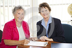 Senior Woman Signing Paperwork