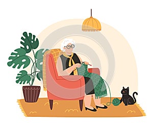 Senior woman sits in an armchair and knits a scarf in a cozy room