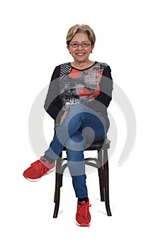 Senior woman sitting on chair on white background