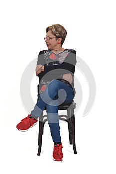 Senior woman sitting on chair on white background