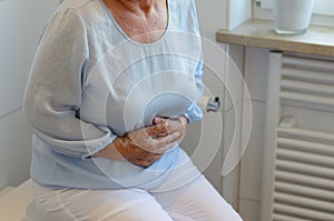 Senior woman sitting on toilet