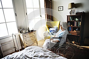 Senior woman sitting on the wheelchair alone photo