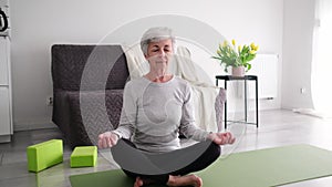 Senior Woman Sitting In Yoga Lotus Position