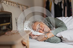 Senior woman sleeping in her bed alone.