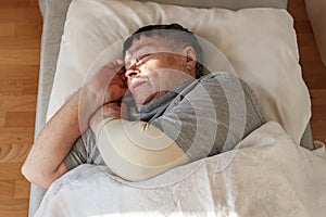 Senior woman sleeping on her bed. Relaxation concept, National napping day. Close up, selective focus